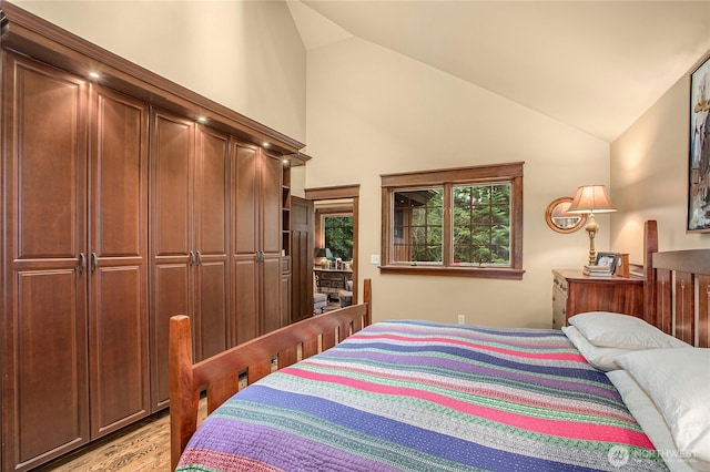 bedroom featuring light wood-style floors and vaulted ceiling