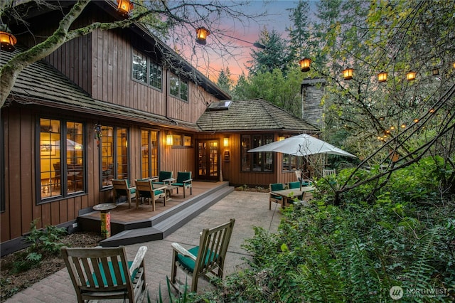 back of property at dusk featuring a deck and french doors