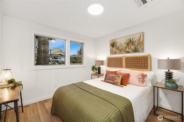 bedroom with wood finished floors and baseboards