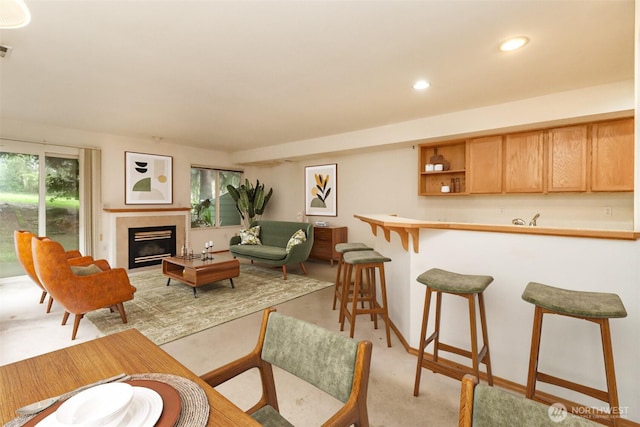 living room with recessed lighting, visible vents, bar, and a glass covered fireplace