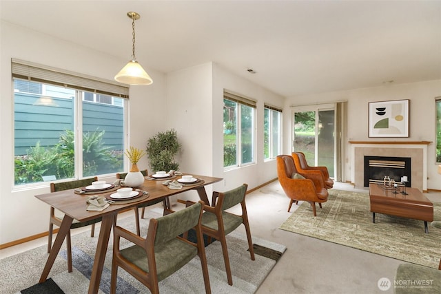 dining room featuring a tile fireplace, visible vents, and baseboards