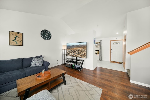 living room with lofted ceiling, wood finished floors, stairs, and baseboards