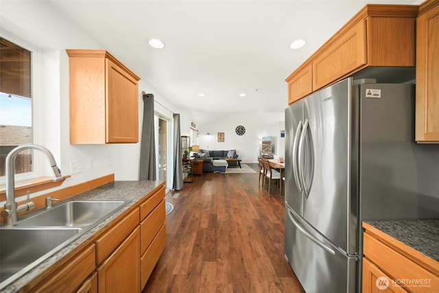 kitchen featuring dark countertops, dark wood-style floors, open floor plan, freestanding refrigerator, and a sink