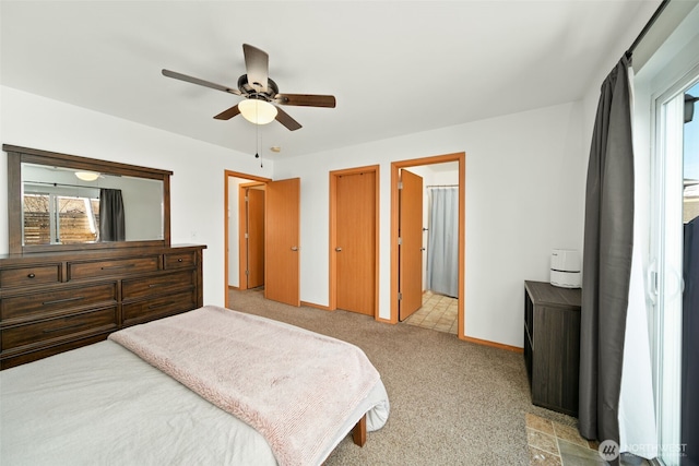 bedroom with light carpet, ensuite bath, ceiling fan, and baseboards