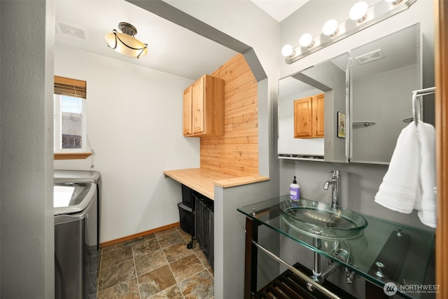 bathroom featuring visible vents, stone finish flooring, vanity, independent washer and dryer, and baseboards