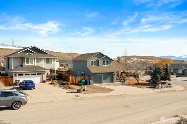 traditional home with a garage, a residential view, and concrete driveway