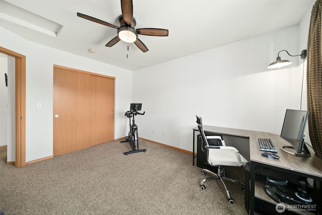 carpeted office space with ceiling fan and baseboards