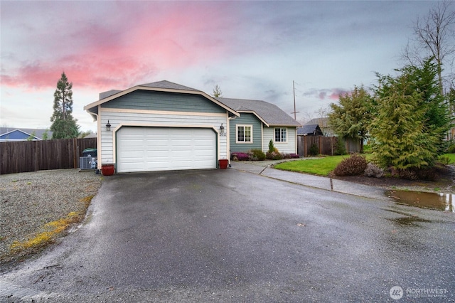 ranch-style house featuring a garage, driveway, and fence