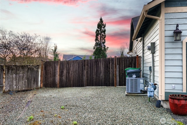 view of yard featuring central AC and fence