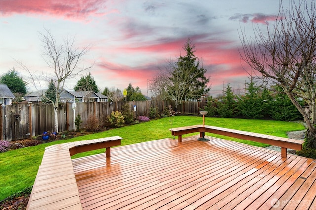 deck at dusk featuring a fenced backyard and a yard