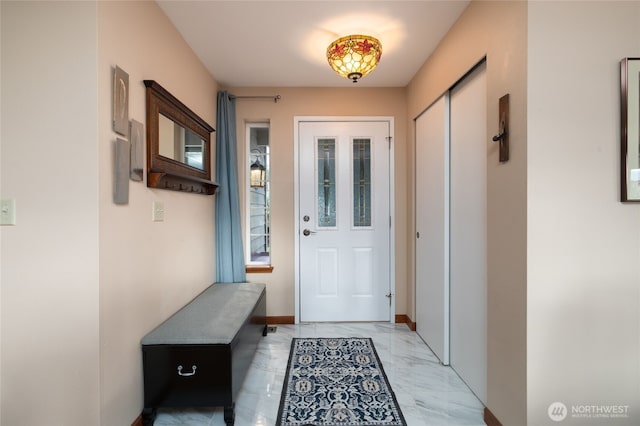 entryway featuring marble finish floor and baseboards