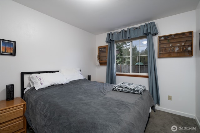 bedroom with baseboards and dark colored carpet