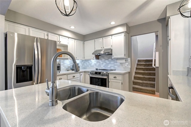 kitchen with stainless steel appliances, decorative backsplash, white cabinetry, and under cabinet range hood