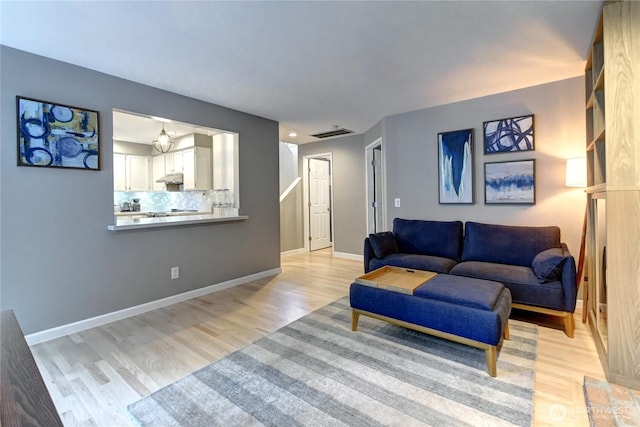 living area with light wood finished floors, baseboards, and visible vents