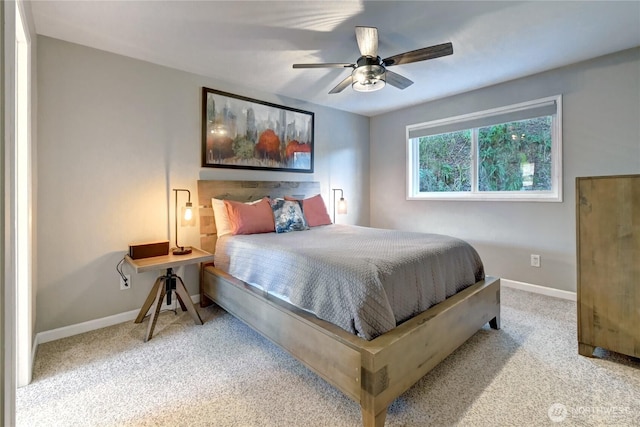 carpeted bedroom with ceiling fan and baseboards