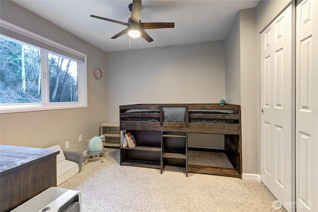 carpeted bedroom featuring baseboards and a ceiling fan