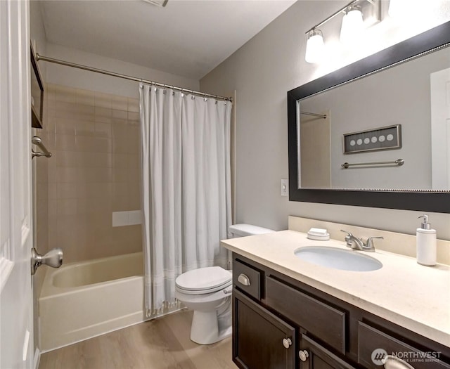 full bath featuring toilet, shower / bath combo, wood finished floors, and vanity