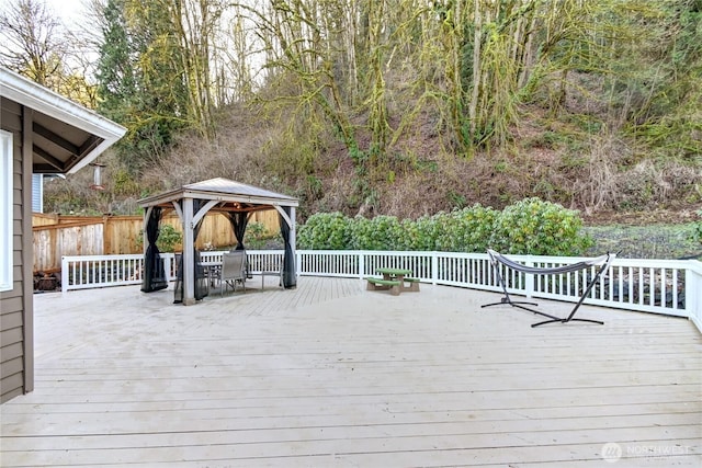 wooden deck featuring a gazebo and fence