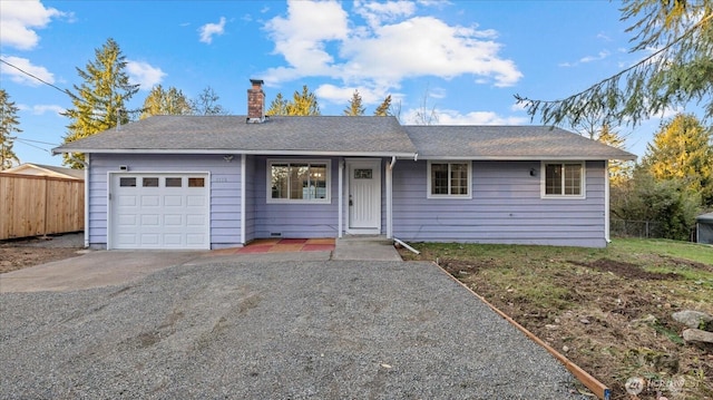 ranch-style home with gravel driveway, fence, a chimney, and an attached garage