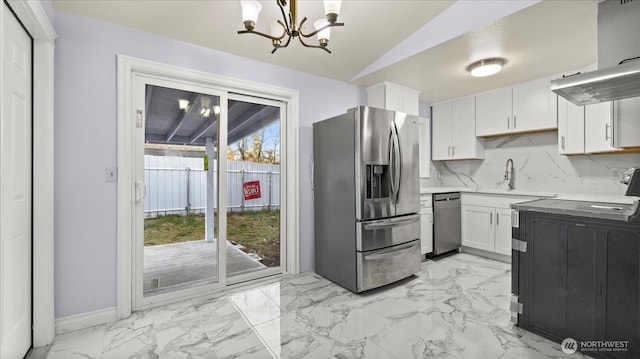 kitchen featuring decorative backsplash, appliances with stainless steel finishes, vaulted ceiling, white cabinetry, and a sink