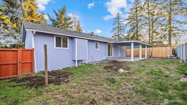 rear view of house with a yard, a patio area, and a fenced backyard