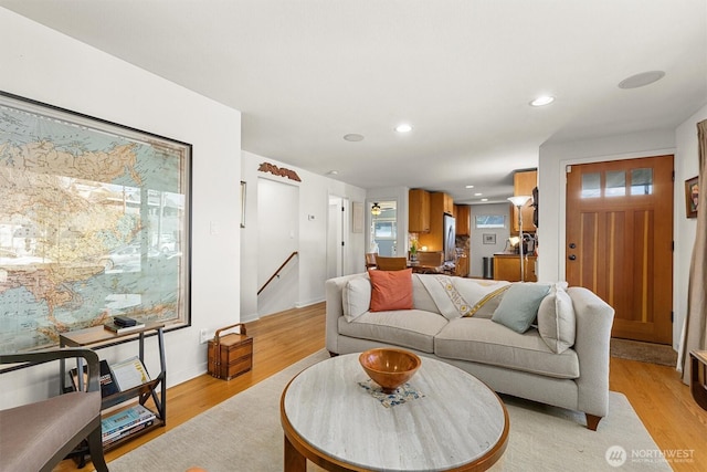 living room with baseboards, recessed lighting, and light wood-style floors