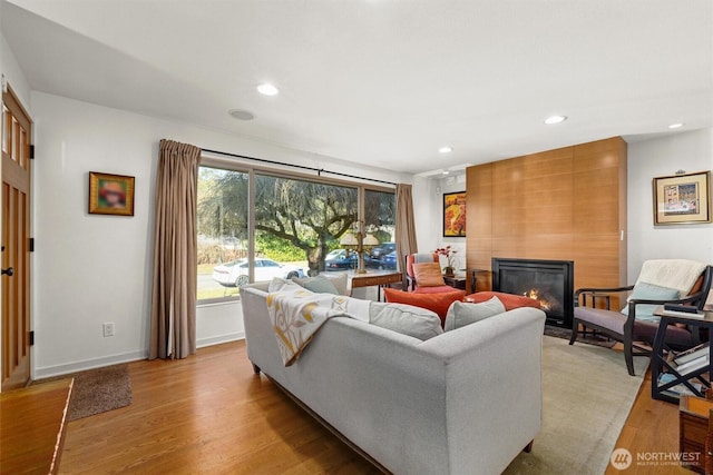 living room with recessed lighting, a fireplace, and light wood finished floors