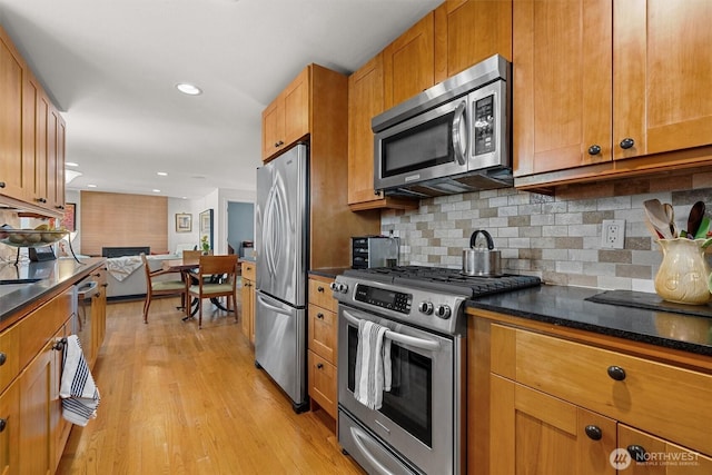 kitchen with recessed lighting, stainless steel appliances, brown cabinets, light wood finished floors, and tasteful backsplash