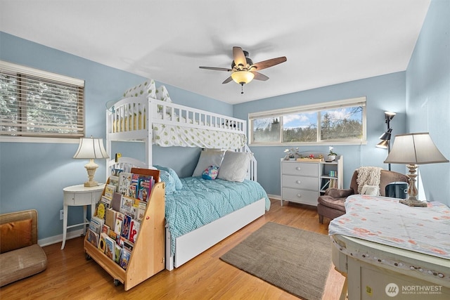 bedroom featuring ceiling fan, baseboards, and wood finished floors