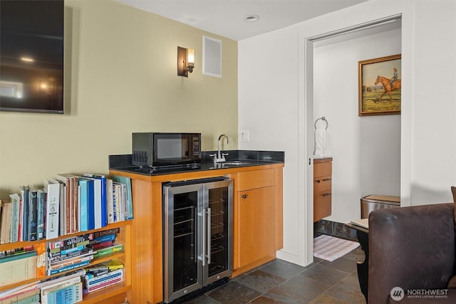 bar featuring wine cooler, visible vents, stone finish floor, a sink, and black microwave