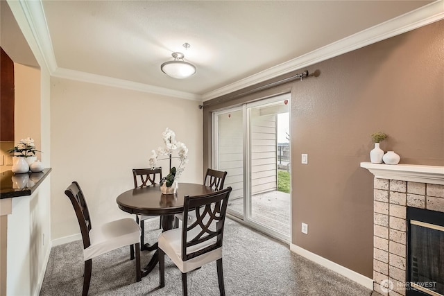 dining space with baseboards, ornamental molding, carpet flooring, and a tile fireplace