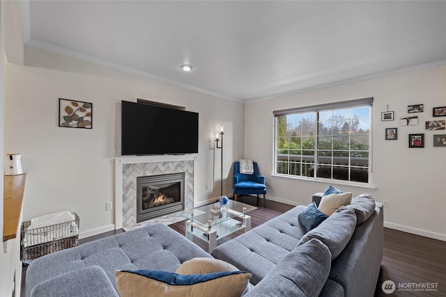 living area featuring ornamental molding, a tiled fireplace, wood finished floors, and baseboards