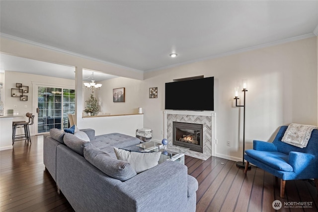 living room featuring dark wood-style floors, a tiled fireplace, baseboards, and crown molding