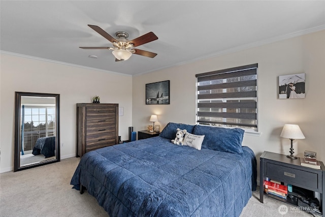 carpeted bedroom with ceiling fan, baseboards, and crown molding