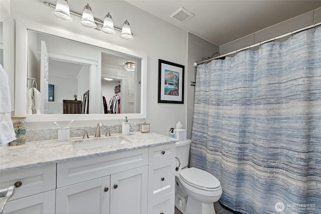 bathroom with visible vents, vanity, and toilet