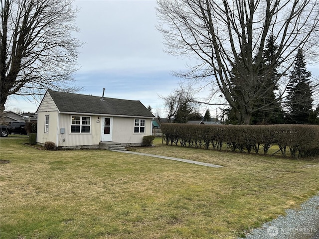 exterior space featuring a shingled roof and a front lawn