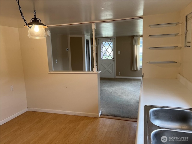 interior space featuring a sink, wood finished floors, and baseboards