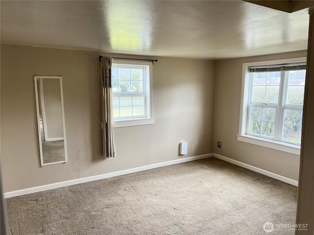 unfurnished room with carpet and baseboards