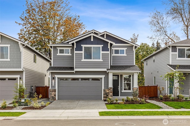 craftsman-style house with concrete driveway, board and batten siding, fence, a garage, and stone siding