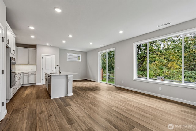 kitchen with recessed lighting, light countertops, visible vents, dark wood-type flooring, and a sink