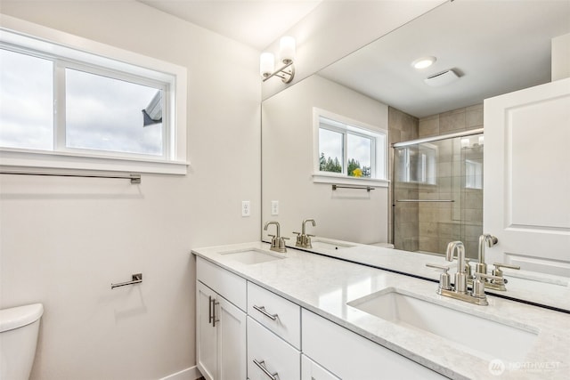 full bath with a stall shower, a sink, and toilet