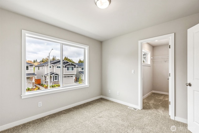 spare room with visible vents, baseboards, and carpet flooring