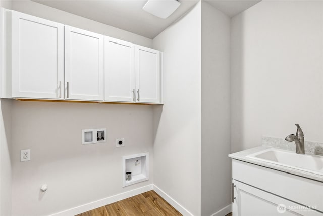 laundry room with hookup for a washing machine, cabinet space, a sink, electric dryer hookup, and light wood-type flooring