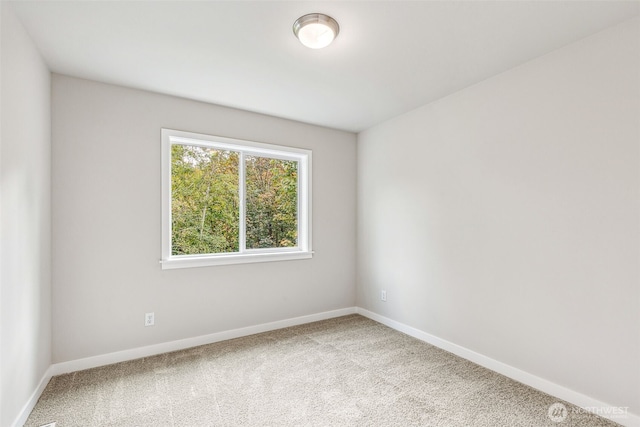 unfurnished room featuring carpet and baseboards