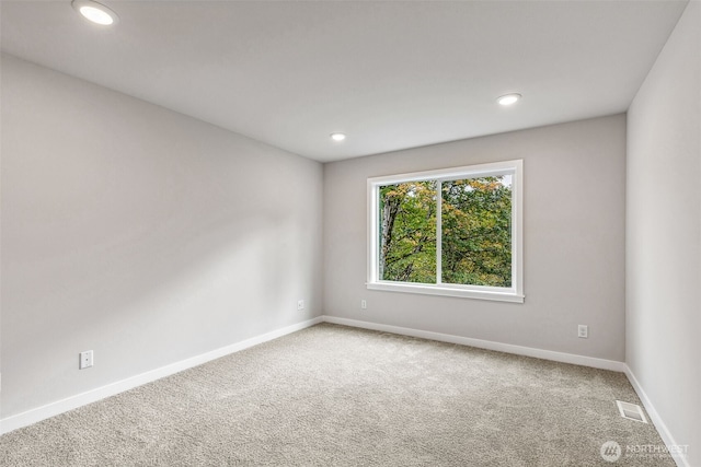 spare room with carpet floors, recessed lighting, visible vents, and baseboards