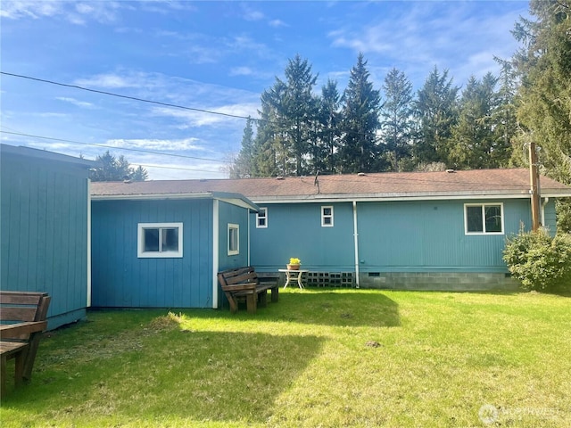 back of property featuring entry steps, crawl space, and a lawn