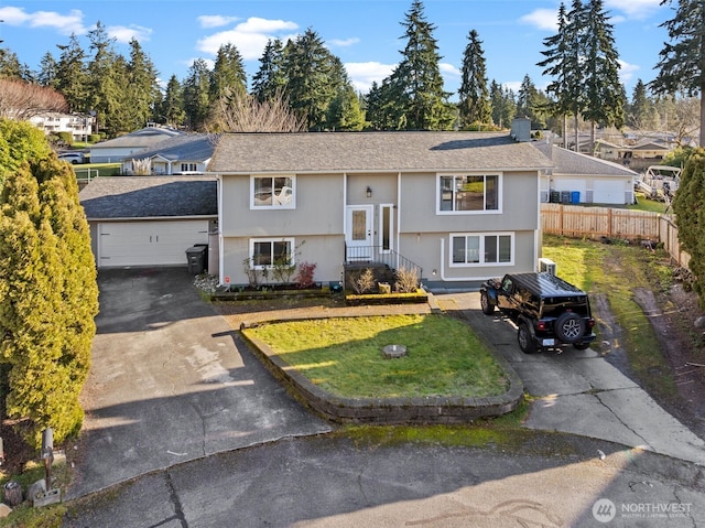 split foyer home with aphalt driveway, a front yard, fence, and a garage