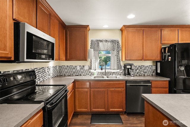 kitchen featuring dark wood-style floors, recessed lighting, decorative backsplash, a sink, and black appliances