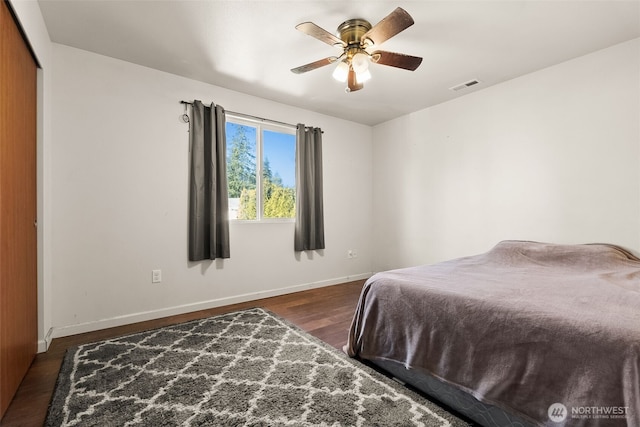 bedroom with a closet, visible vents, ceiling fan, wood finished floors, and baseboards