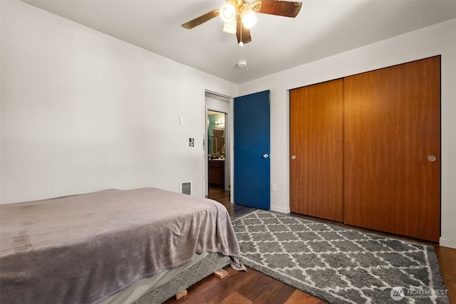 bedroom with dark wood-style floors, ceiling fan, visible vents, and a closet